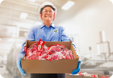 Smiling Babybel® worker holding a box of snack cheese